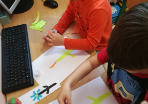 Dzieci wydzierają kolorowy papier tworząc obrazek.
