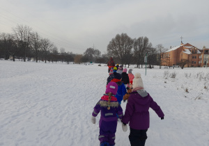 Dzieci spacerują po zimowym parku.