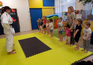 Dzieci trenują judo z trenerem.