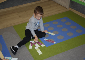 Chłopiec układa puzzle.