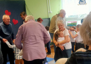 Dzieci tańczą z dziadkami.