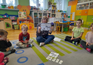 Nauczycielka prezentuje dzieciom ilustrację.
