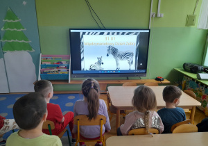 Dzieci oglądają prezentację na temat zeber.