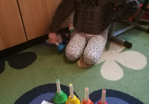  Dziewczynka układa dzwonki wg schematu kolorów.