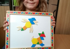 Dzieci układają obrazki z figur na tablicy magnetycznej.