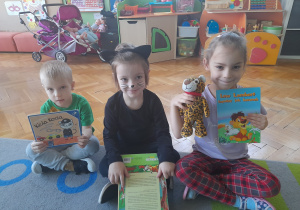 Dzieci prezentują przyniesione przez siebie maskotki i książki o kotach.