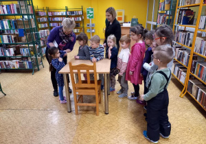 Dzieci wykonują zadanie w bibliotece.