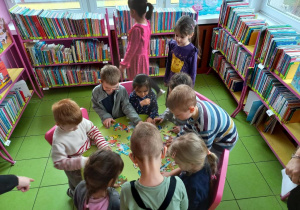 Dzieci wykonują zadanie w bibliotece.