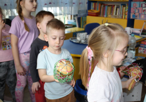 Dzieci bawią się z królem Julianem do muzyki granej na bębnach.
