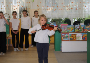 Dziewczynka gra na skrzypcach.
