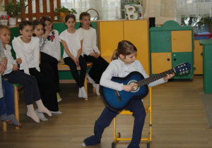 Dziewczynka gra na gitarze.