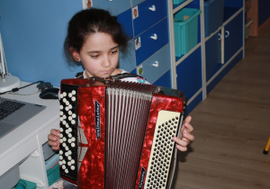 Gra na akordeonie przez dziewczynkę z gr. 2