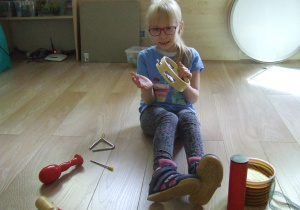 Dziewczynka gra na instrumentach.
