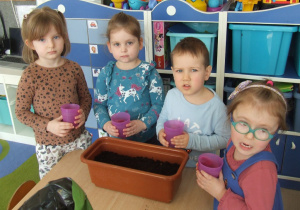 Dzieci podlewają zasiane nasiona roślin.