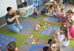 Nauczycielka prezentuje dzieciom przyniesione nasiona i cebulki roślin