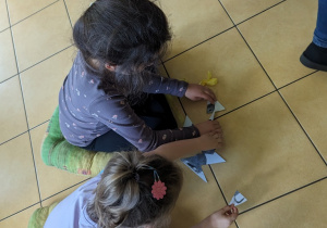 Dzieci w zespołach układają puzzle.