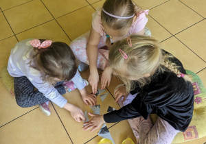 Dzieci w zespołach układają puzzle.