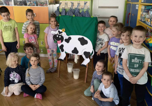 Dzieci prezentują obraz krowy.