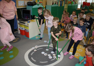 Dzieci uczestniczą w zabawie segregowania śmieci.