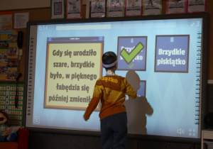 Zagadki na tablicy multimedialnej rozwiązywane przez dzieci.