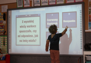 Zagadki na tablicy multimedialnej rozwiązywane przez dzieci.