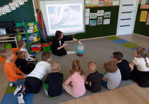 Nauczycielka pokazuje globus.