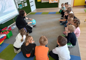 Nauczycielka pokazuje globus.