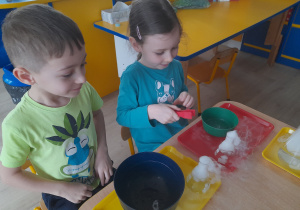 Dzieci wykonują eksperyment z suchym lodem.