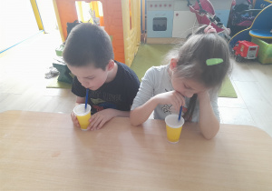 Dzieci piją napój.