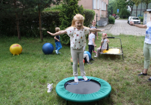 Dziewczynka skacze na trampolinie.