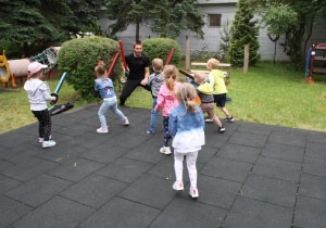 Dzieci wykonują ćwiczenia z bezpiecznymi szablami.