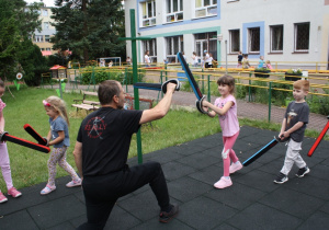 Dzieci wykonują ćwiczenia z bezpiecznymi szablami.