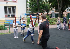 Dzieci wykonują ćwiczenia z bezpiecznymi szablami.