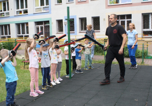 Dzieci wykonują ćwiczenia z bezpiecznymi szablami.