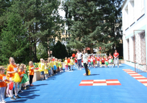 Dzieci na tarasie przedszkolnym wydają okrzyk do biegu.