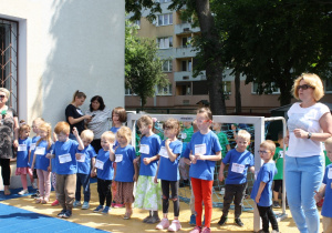 Dzieci na tarasie przedszkolnym wydają okrzyk do biegu.