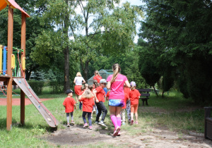 Grupa piąta biegnie po terenie ogrodu.