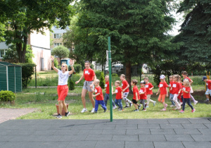 Grupa piąta biegnie po terenie ogrodu.