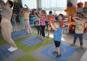 Dzieci powtarzają układ taneczny po nauczycielce.