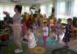 Dzieci powtarzają układ taneczny po nauczycielce.