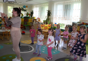 Dzieci powtarzają układ taneczny po nauczycielce.