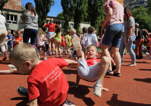 Dzieci tańczą na boisku.