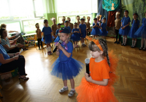 Dziewczynki zapraszają zebranych gości na występ.