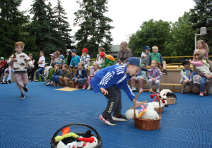 Dzieci przenoszą jedzonko dla bocianów.