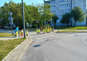 Dzieci przechodzą po pasach przez ulicę.