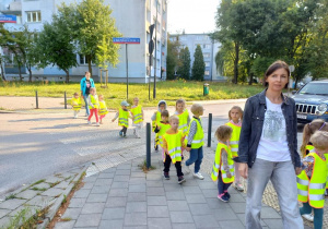 Dzieci przechodzą po pasach przez ulicę.