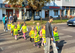 Dzieci przechodzą po pasach oraz przy zielonym świetle dla pieszych.