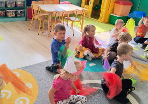 Dzieci machają kolorowymi chustkami.