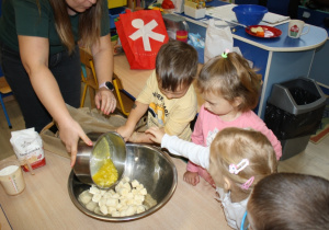 Chłopiec przelewa roztopione masło do bananów.