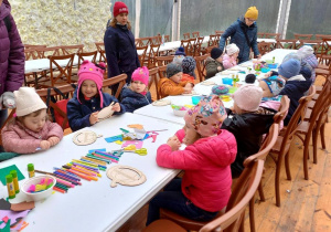 Dzieci wykonują ozdoby na warsztatach plastycznych.